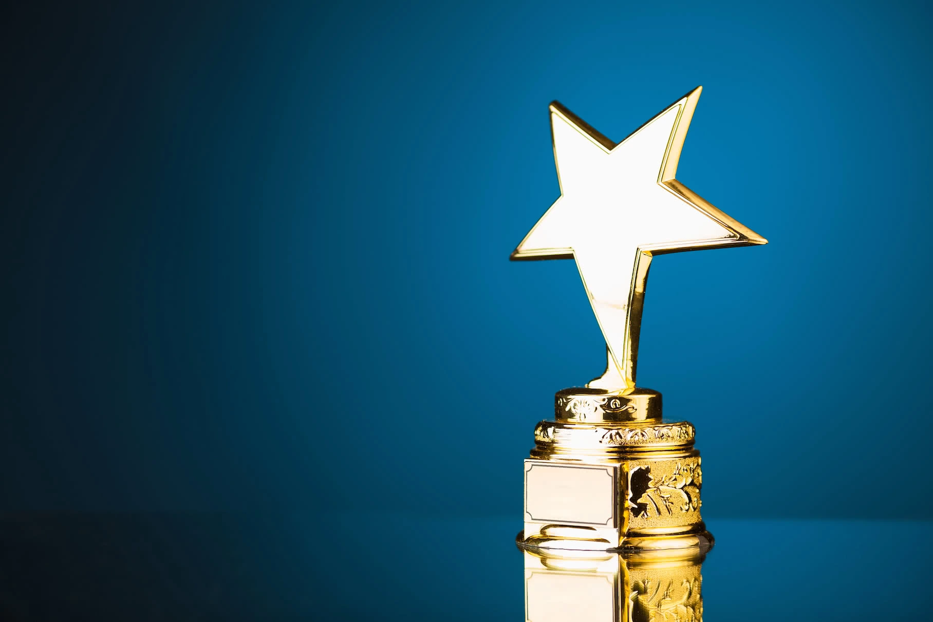 Elegant awards ceremony with illuminated stage, branded backdrop, award trophies, and audience seating